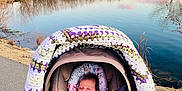 Aurora is registered to the contest to win money with this photo: baby, stroller, blanket, bottle, hand, path, lake, water, sunset, sky, trees, reflection, nature, outdoor, peaceful, crochet, purple, pink, person, landscape