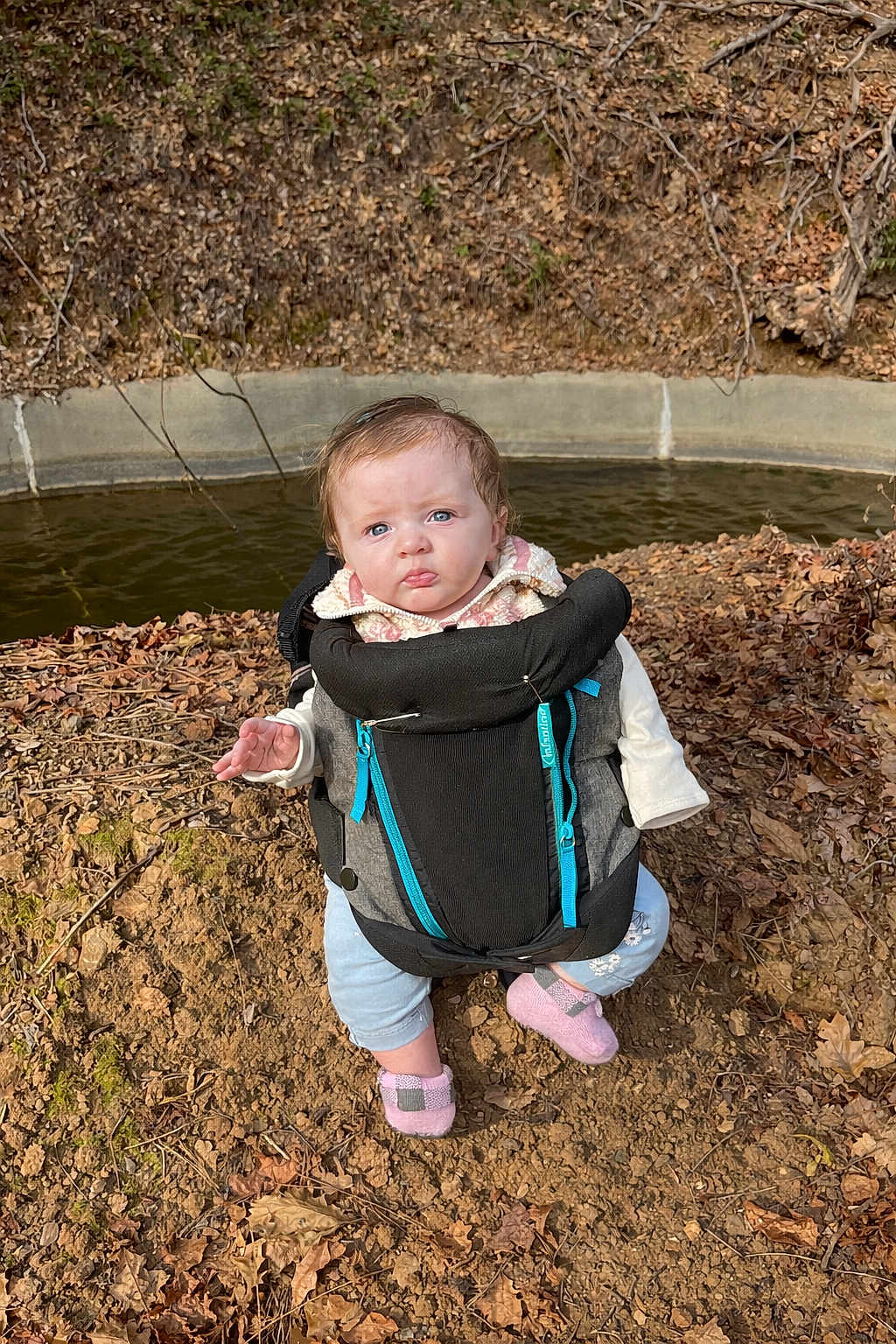 Aurora joined the competition — help win amazing prizes! baby, child, baby_carrier, outdoor, nature, leaves, soil, water, blue_eyes, pink_shoes, jacket, curly_hair, person, sitting, autumn, fall, expression, ground, daylight, small_child