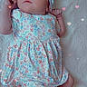 baby, infant, child, floral_dress, headband, blanket, lying_down, cute, heart_overlay, soft_texture, pastel_colors, socks, portrait, adorable, newborn, peaceful, indoor, young_child, baby_girl, cozy