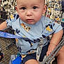 Cooper is registered to the contest to win money with this photo: baby, child, shopping_cart, clothing, rack, store, blue_shirt, shorts, seat_belt, face, head, eyes, hand, foot, retail, shopping, toddler, indoor, person, cute