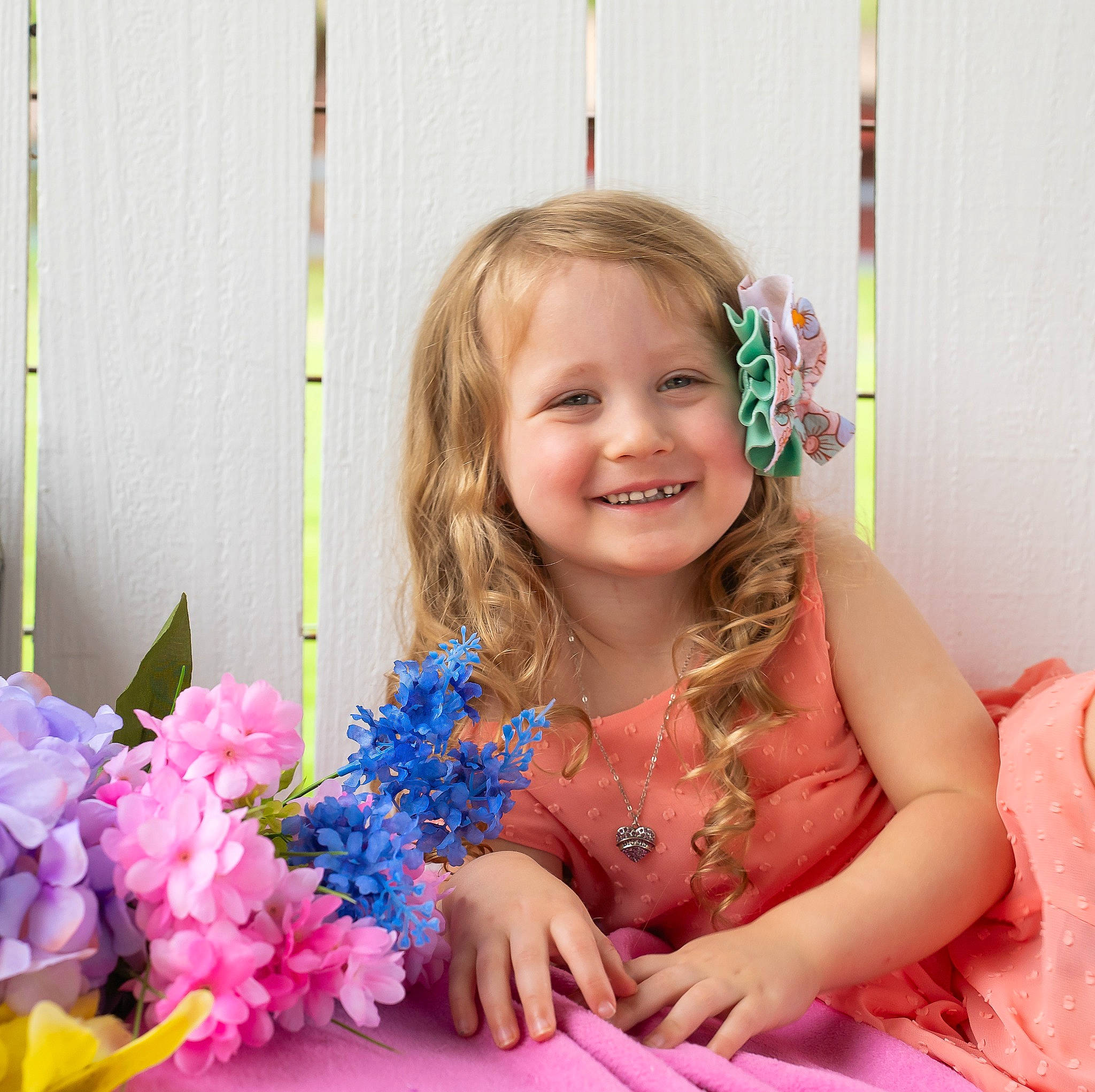 Elizabeth is registered to the contest to win money with this photo: baby, child, dress, electric_blue, event, face, facial_expression, floral_design, flower, flower_arranging, fun, happy, iris, joy, lei, magenta, person, petal, pink, plant