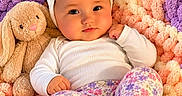 Blakeleigh is registered to the contest to win money with this photo: baby, blanket, bunny, child, close_up, colorful, cozy, feet, floral_clothing, flower_headband, indoors, infant, lying_down, pastel_colors, photography, portrait, smiling, stuffed_animal, toy, wide_eyed