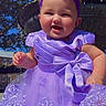 Blakeleigh is registered to the contest to win money with this photo: baby, child, infant, portrait, smiling, happy, purple_dress, princess_dress, hair_bow, headband, outdoor, fountain, water, garden, sunlight, greenery, trees, lace, sitting, fashion