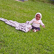 Akoa joined the competition — help win amazing prizes! blanket, casual_clothing, child, curious, daylight, footwear, front_yard, grass, greenery, happy, hoodie, house, lawn, nature, outdoor, person, plaid, sitting, steps, toddler