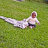 blanket, casual_clothing, child, curious, daylight, footwear, front_yard, grass, greenery, happy, hoodie, house, lawn, nature, outdoor, person, plaid, sitting, steps, toddler
