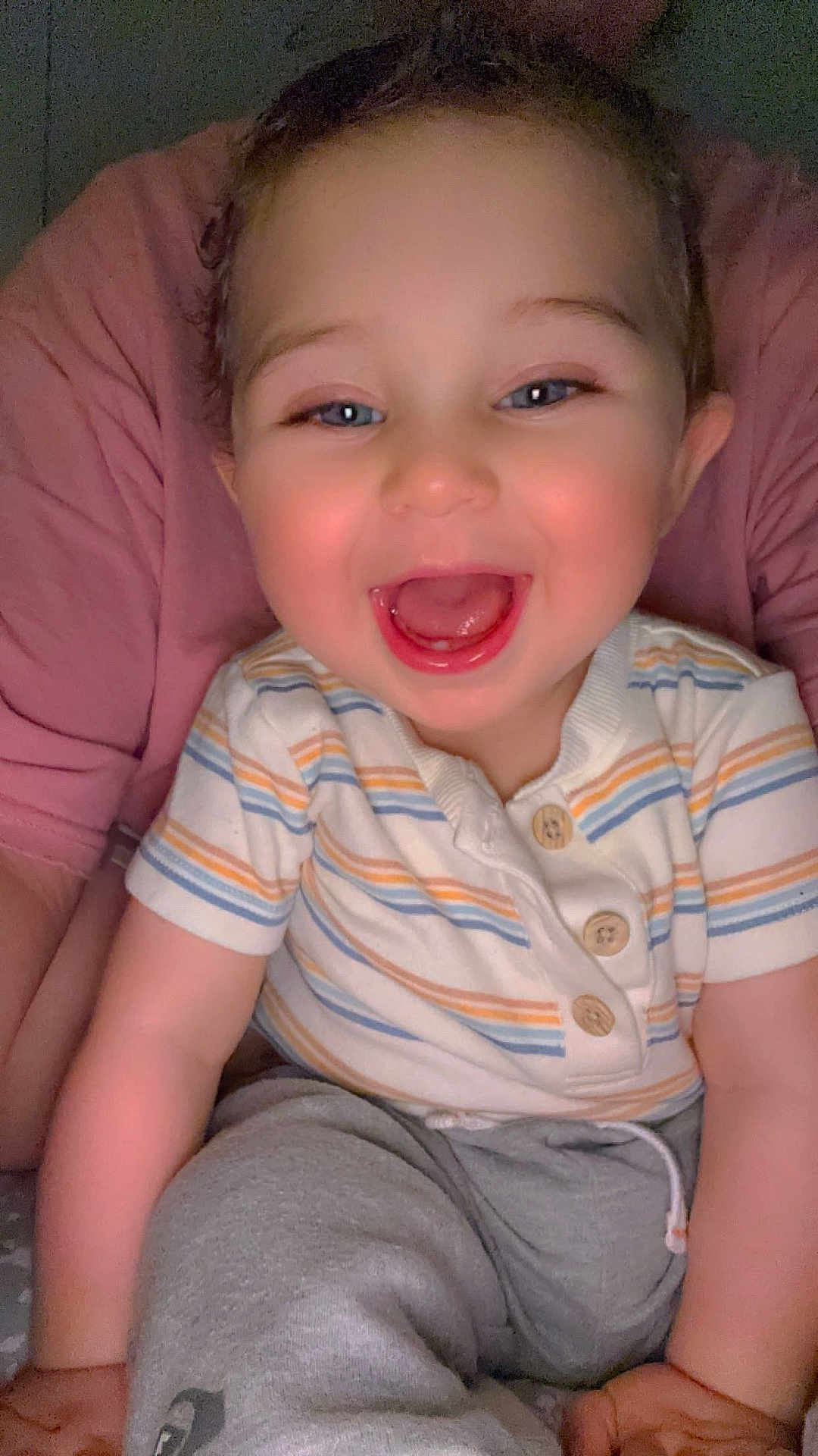 Adriel is registered to the contest to win money with this photo: baby, child, smile, happy, person, face, blue_eyes, striped_shirt, grey_pants, sitting, cute, joyful, infant, human, portrait, indoor, casual_clothing, mouth_open, short_hair, skin