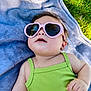 Scarlett is registered to the contest to win money with this photo: baby, child, sunglasses, heart_shaped, green_clothing, blanket, outdoor, grass, cute, relaxed, sunlight, portrait, infant, summer, fashion, accessory, skin, face, hand, lying_down
