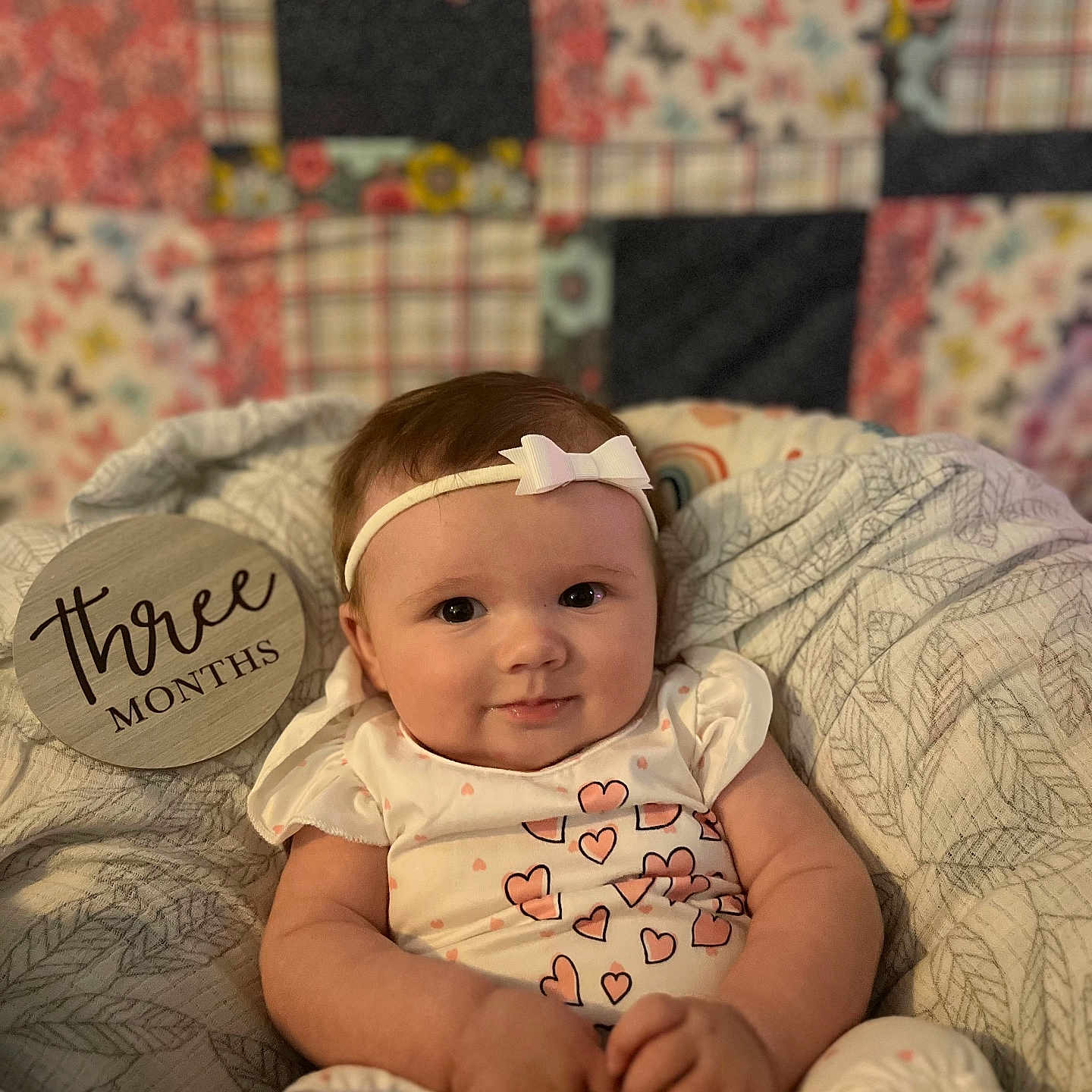 Gracelyn is registered to the contest to win money with this photo: accessories, baby, bed, bedroom, clothing, cushion, face, furniture, happy, head, homedecor, indoors, newborn, person, photography, portrait, quilt, room, sunglasses, t_shirt