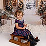 Mimi joined the competition — help win amazing prizes! child, girl, sled, wooden_sled, plaid_dress, winter, holiday, christmas, present, gift, snow, decorations, pine_tree, lantern, rope, indoor, portrait, cute, seasonal, festive