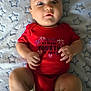 Karson is registered to the contest to win money with this photo: baby, infant, child, red_onesie, blanket, stars_pattern, face, hands, legs, cute, indoors, portrait, laying_down, expression, skin, newborn, clothing, baby_girl_or_boy, celebration, holiday_outfit
