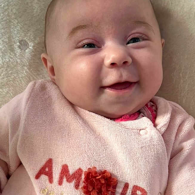 Siyannah participe au concours pour gagner de l'argent avec cette photo : baby, blanket, child, closeup, comfortable, cozy, cute, face, flower_decoration, happy, indoors, infant, lying_down, person, pink_clothing, portrait, smiling, soft_texture, toddler, warm
