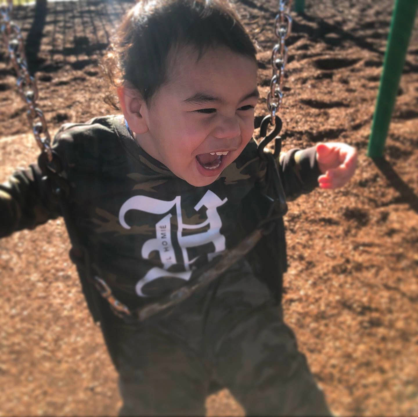 Kymani joined the competition — help win amazing prizes! child, cool, fun, happy, outdoor_play_equipment, person, play, playground, public_space, smile, soil, swing, t_shirt, toddler