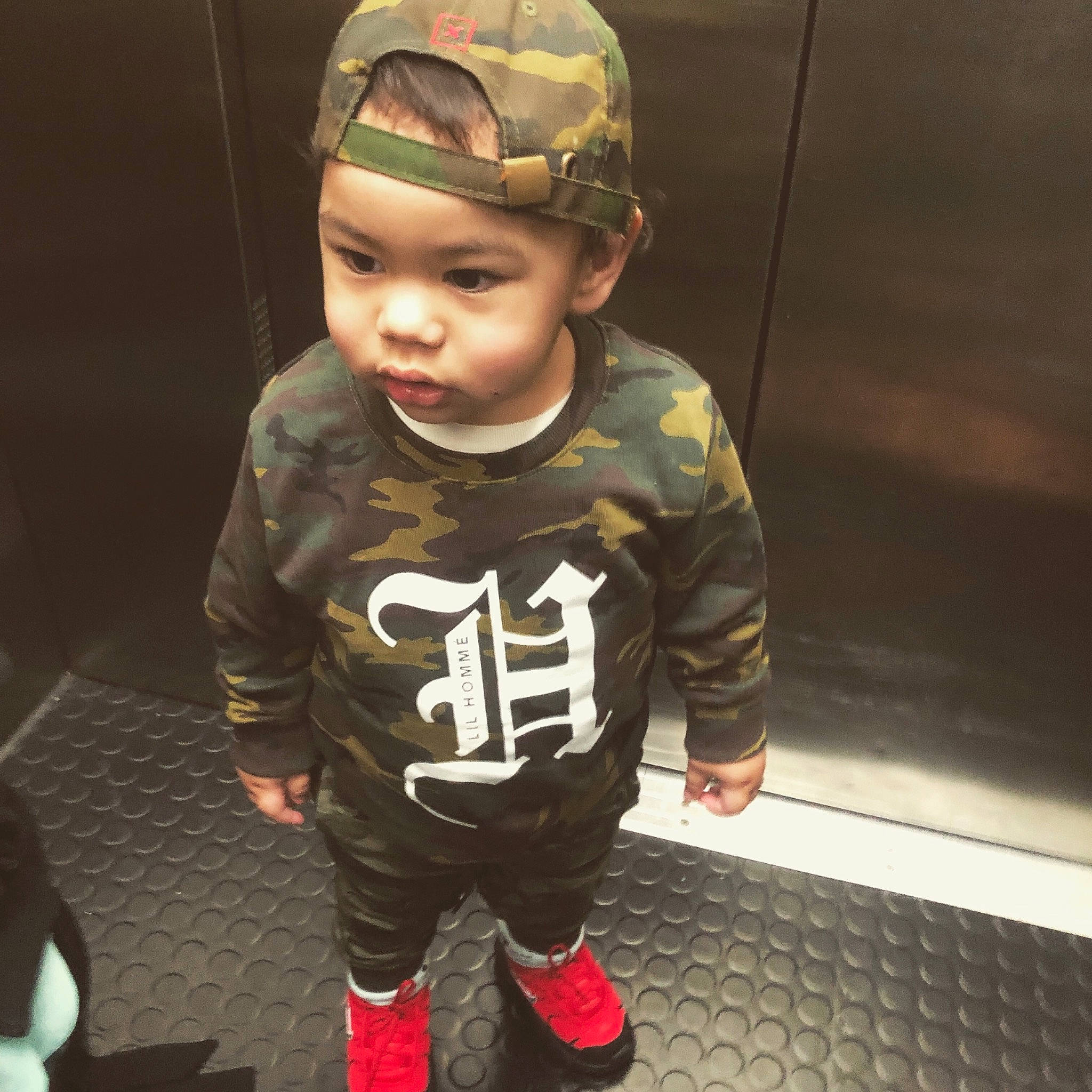 Kymani joined the competition — help win amazing prizes! baby, camouflage, cheek, child, cool, design, face, head, headwear, outerwear, person, personal_protective_equipment, play, sleeve, sportswear, t_shirt, toddler, uniform