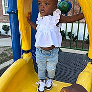 Amara joined the competition — help win amazing prizes! brick_building, casual, child, curious, daytime, fashion, handrail, jeans, outdoor, person, play_equipment, playground, slide, sneakers, standing, toddler, urban, white_top, windows, yellow_slide