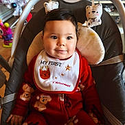 Leyna a rejoint le concours — aidez-le/la à gagner de superbes lots ! baby, child, infant, pajamas, bib, christmas, holiday, indoor, baby_seat, smiling, cute, face, person, teddy_bear_pattern, toy, decorations, festive, red_clothing, seat, happy