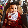 baby, child, infant, pajamas, bib, christmas, holiday, indoor, baby_seat, smiling, cute, face, person, teddy_bear_pattern, toy, decorations, festive, red_clothing, seat, happy