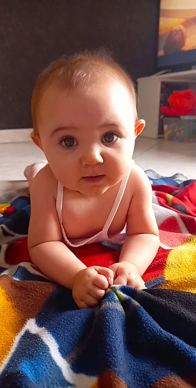 Zoé participe au concours pour gagner de l'argent avec cette photo : baby, baby_toddler_clothing, cheek, child, comfort, finger, flooring, fun, gesture, happy, iris, lip, mouth, nail, nose, person, skin, smile, surprise, thumb