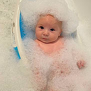 Carter is registered to the contest to win money with this photo: baby, bath, bubbles, foam, water, child, blue, skin, face, head, sitting, cute, infant, clean, relaxing, bubble_crown, bathtub, playful, young, person