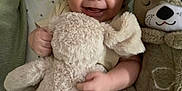 Carter joined the competition — help win amazing prizes! baby, smiling, stuffed_animal, plush_toy, blanket, infant, happy, cute, child, soft, cozy, indoors, sleeping_area, toddler, face, cuddly, comfort, toy, person, lying_down