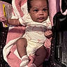 baby, infant, car_seat, blanket, onesie, towel, sock, child, cute, indoors, portrait, face, clothing, pink, white, soft_texture, seat, person, newborn, comfort