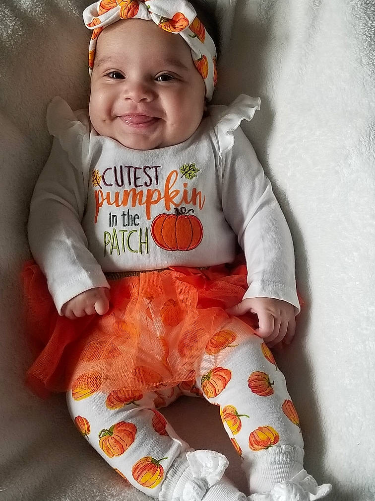 Moon Jade joined the competition — help win amazing prizes! baby, baby_products, baby_toddler_clothing, cap, child, face, happy, headwear, joy, orange, pattern, peach, person, pink, product, sitting, skin, sleeve, smile, t_shirt