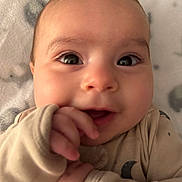 Jr. joined the competition — help win amazing prizes! baby, infant, close_up, face, eyes, hand, pajamas, beige, blanket, soft, cute, smile, child, young, skin, portrait, indoors, expression, lying_down, cozy