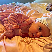 Jasmine is registered to the contest to win money with this photo: baby, infant, pink_clothing, headband, white_bow, blanket, soft_fabric, cute, face, hand, lying_down, indoors, close_up, newborn, sleepwear, bed, cozy, skin, portrait, child
