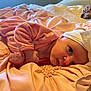 baby, infant, pink_clothing, headband, white_bow, blanket, soft_fabric, cute, face, hand, lying_down, indoors, close_up, newborn, sleepwear, bed, cozy, skin, portrait, child