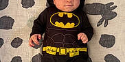 Siul joined the competition — help win amazing prizes! baby, infant, batman_costume, cape, black_clothing, lying_down, blanket, patterned_blanket, face, cute, child, superhero, costume, small_hands, black_socks, indoor, portrait, expression, young_child, adorable