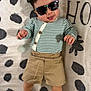 Siul joined the competition — help win amazing prizes! baby, child, sunglasses, striped_shirt, khaki_shorts, white_socks, tongue_out, polka_dot_blanket, cute, playful, infant, lying_down, clothing, person, face, head, smile, hand, foot, patterned_background