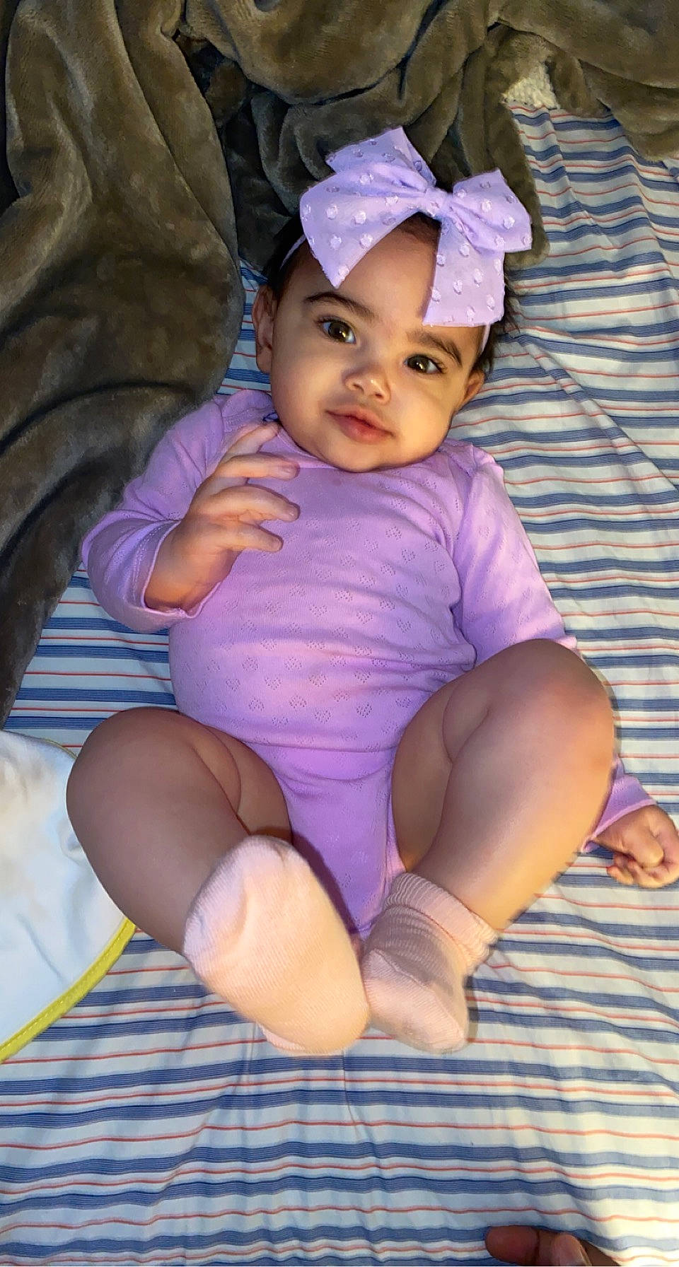 Sariyah joined the competition — help win amazing prizes! baby, baby_toddler_clothing, cap, child, comfort, eye, face, fun, happy, head, headwear, human_leg, knee, person, pink, purple, sitting, sleeve, sock, thigh