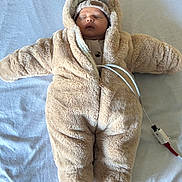 Noam participe au concours pour gagner de l'argent avec cette photo : baby, sleeping, infant, onesie, fluffy_clothing, hat, lying_down, medical_sensor, wire, bed, blanket, cozy, cute, child, soft_texture, warm_clothing, indoors, portrait, peaceful, newborn