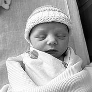 Joseph joined the competition — help win amazing prizes! newborn, baby, sleeping, blanket, hat, wrapped, infant, cozy, soft, peaceful, closeup, portrait, monochrome, black_and_white, resting, cute, child, indoors, serene, calm