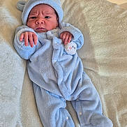 Duarte participe au concours pour gagner de l'argent avec cette photo : baby, bear_ears, blanket, blue_onesie, child, clothing, cozy, cute, expression, face, footed_pajamas, hand, indoors, infant, newborn, portrait, resting, sleepwear, soft_texture, warm