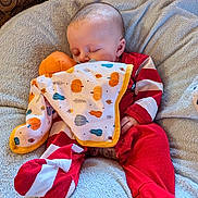 Hudson joined the competition — help win amazing prizes! baby, sleeping, blanket, plush, cushion, red_clothing, striped_clothing, infant, cozy, soft_toy, pacifier, patterned_background, indoor, comfort, child, peaceful, resting, cute, home, portrait