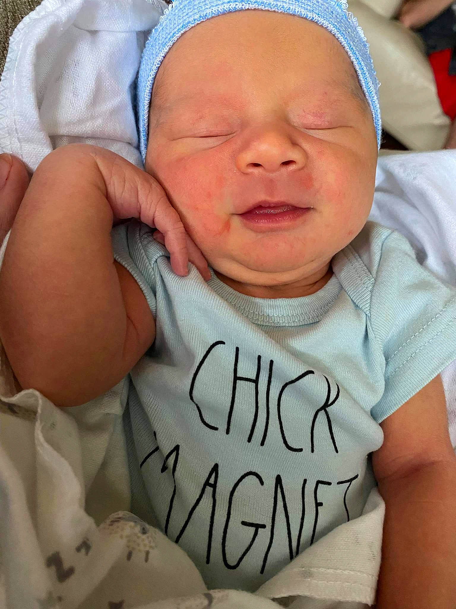 Silas Auman is registered to the contest to win money with this photo: baby, baby_toddler_clothing, cheek, chin, comfort, face, facial_expression, finger, gesture, happy, headgear, human, mouth, organ, person, pink, product, skin, sleeve, smile