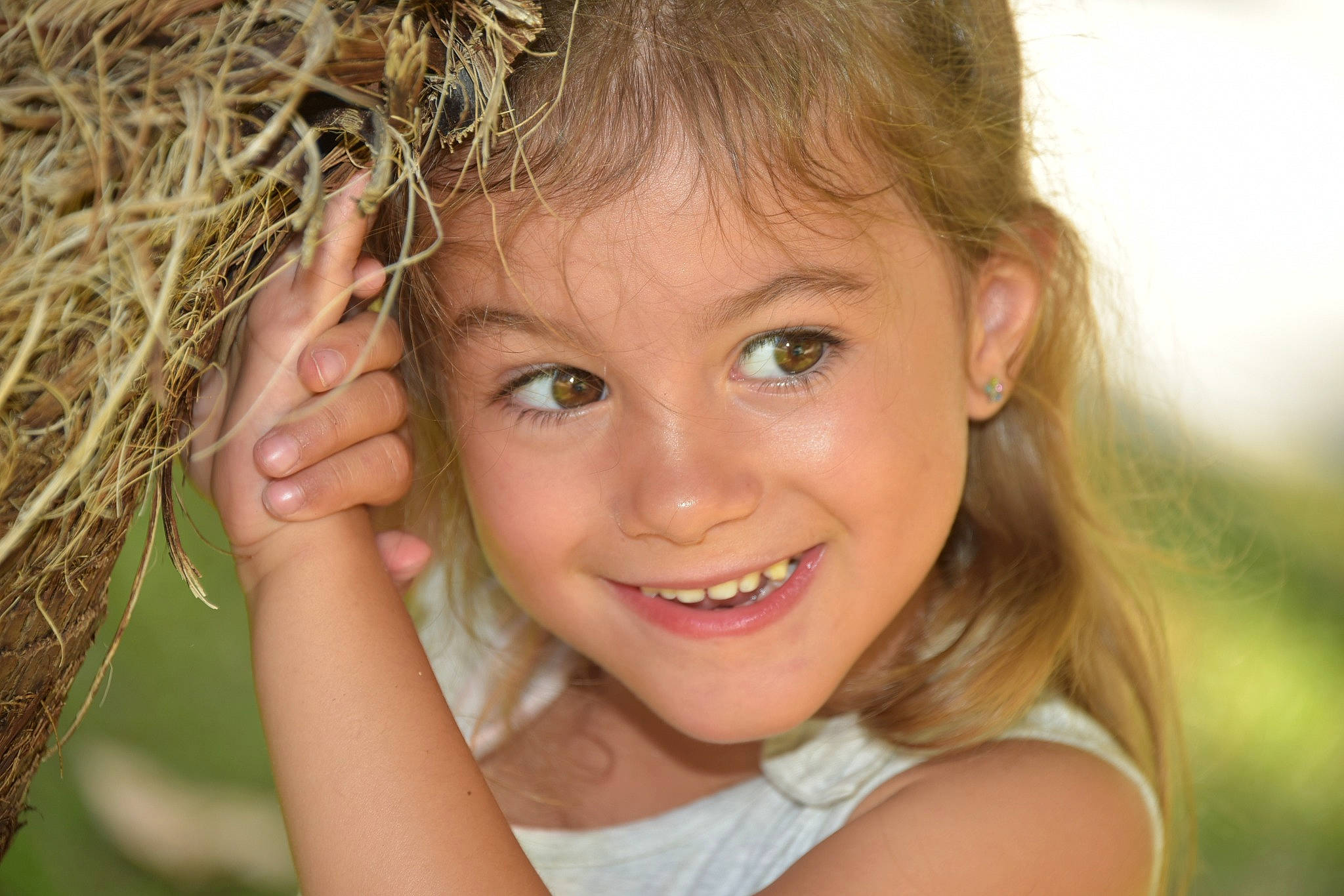 Lea participe au concours pour gagner de l'argent avec cette photo : child, close_up, eyelash, face, facial_expression, flash_photography, fun, grass, happy, iris, joy, lip, long_hair, nose, people_in_nature, person, plant, skin, smile, summer