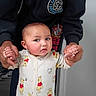 baby, child, onesie, winnie_the_pooh, person, hands, indoor, door, clothing, adult, supporting, walking, curious, standing, sleeves, floor, footwear, hoodie, logo, skin