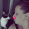 woman, cat, tattoo, face, profile, indoor, pet, black_and_white_cat, curious, close_up, pink_heart, text_overlay, shoulder, pouting, looking, human, animal, window, reflection, casual