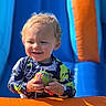 toddler, child, smile, ball, curly_hair, outdoor, inflatable, blue, orange, sunlight, play, fun, happy, young_child, colorful, clothing, person, summer, water, toy