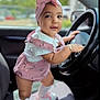 Mia joined the competition — help win amazing prizes! baby, child, car, steering_wheel, pink_bow, headband, pink_outfit, socks, shoes, seat, car_interior, cute, smiling, curious, portrait, indoor, person, fashion, accessories, happy