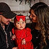 baby, child, woman, man, family, red_dress, headband, portrait, indoor, smile, love, holiday_decor, greenery, jewelry, casual_clothing, hat, long_hair, holding, people, warmth