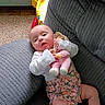 Roselynn joined the competition — help win amazing prizes! baby, baby_shoes, carpet, child, comfort, couch, cute, doll, floral_outfit, gray_fabric, home, indoor, infant, person, playful, relaxing, seated, small, toy, white_sleeves