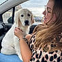 Aïka participe au concours pour gagner de l'argent avec cette photo : dog, puppy, woman, glasses, car_interior, seat, window, scarf, leopard_print, smile, long_hair, bracelet, hand, face, pet, cuddling, casual_clothing, daytime, cloudy_sky, road