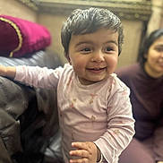 Alayna joined the competition — help win amazing prizes! toddler, child, smiling, happy, indoor, couch, woman, person, clothing, pink_outfit, home, furniture, portrait, baby, face, hand, sitting, blurred_background, cozy, cute