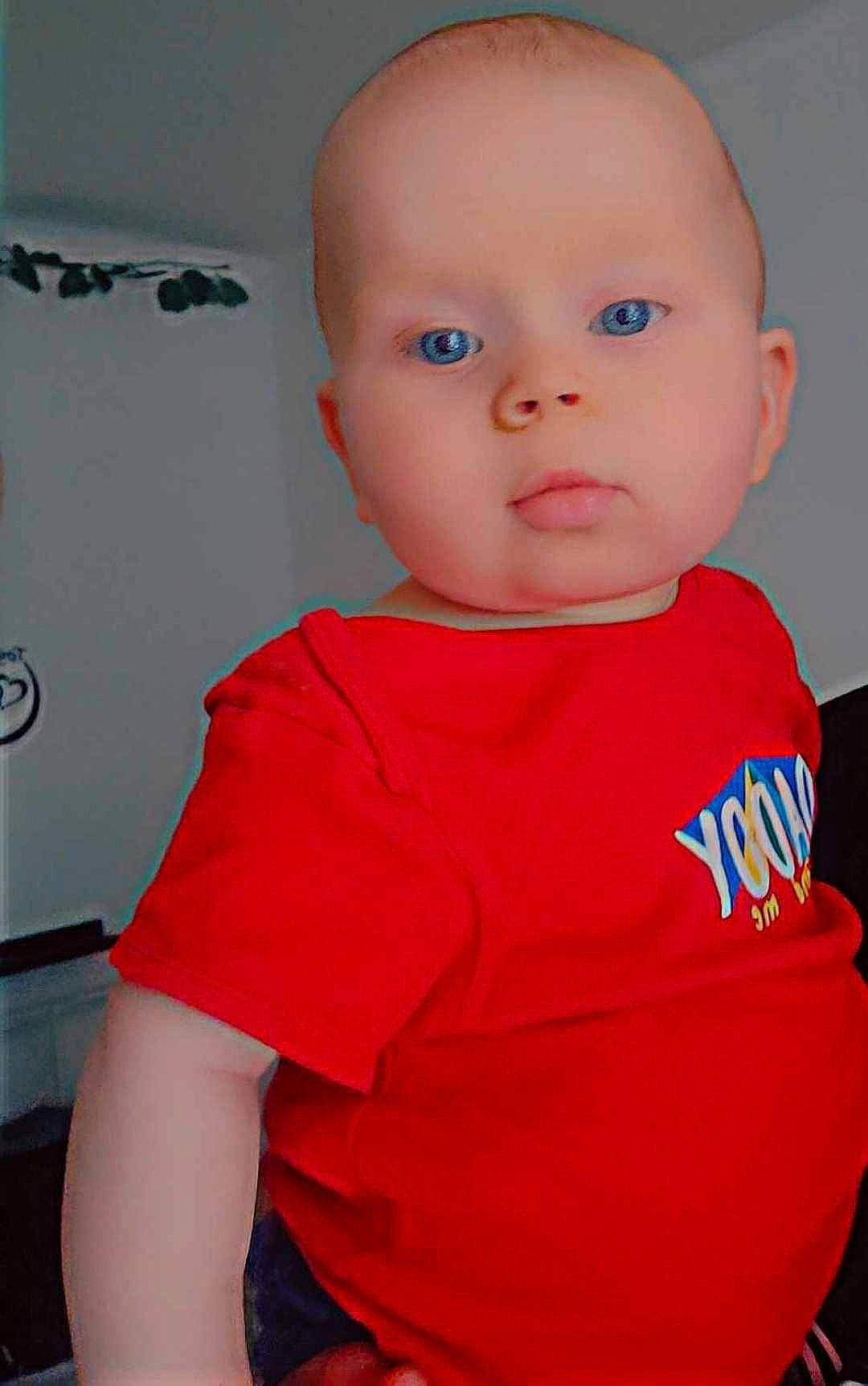 Louis participe au concours pour gagner de l'argent avec cette photo : active_shirt, baby, baby_toddler_clothing, carmine, cheek, chest, child, comfort, elbow, electric_blue, eye, joint, magenta, neck, nose, person, sitting, sleeve, t_shirt, toddler