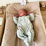 Seven a rejoint le concours — aidez-le/la à gagner de superbes lots ! baby, baby_clothes, baby_room, changing_table, cute, indoors, infant, milestone_card, newborn, onesie, peaceful, plush, resting, sleeping, slippers, soft, teddy_bear, text, towel, wooden