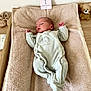 baby, baby_clothes, baby_room, changing_table, cute, indoors, infant, milestone_card, newborn, onesie, peaceful, plush, resting, sleeping, slippers, soft, teddy_bear, text, towel, wooden