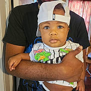 Nicasso is registered to the contest to win money with this photo: accessories, arm, baby, baseballcap, bodypart, cap, clothing, face, glasses, hat, head, indoors, jewelry, necklace, people, person, photography, portrait, shirt, t_shirt