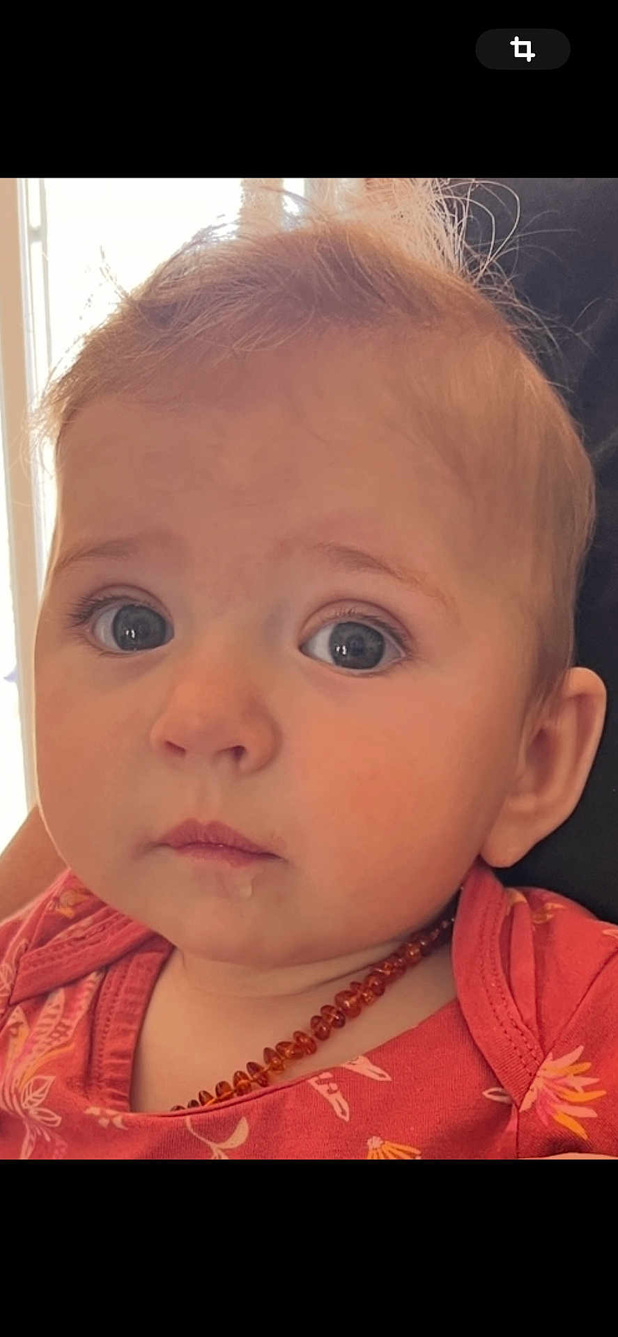 Lilyrose a rejoint le concours — aidez-le/la à gagner de superbes lots ! baby, child, face, close_up, blue_eyes, drool, amber_necklace, pink_clothing, floral_pattern, infant, curious_expression, soft_light, portrait, human, skin, hair, eyelashes, ear, indoors, cute